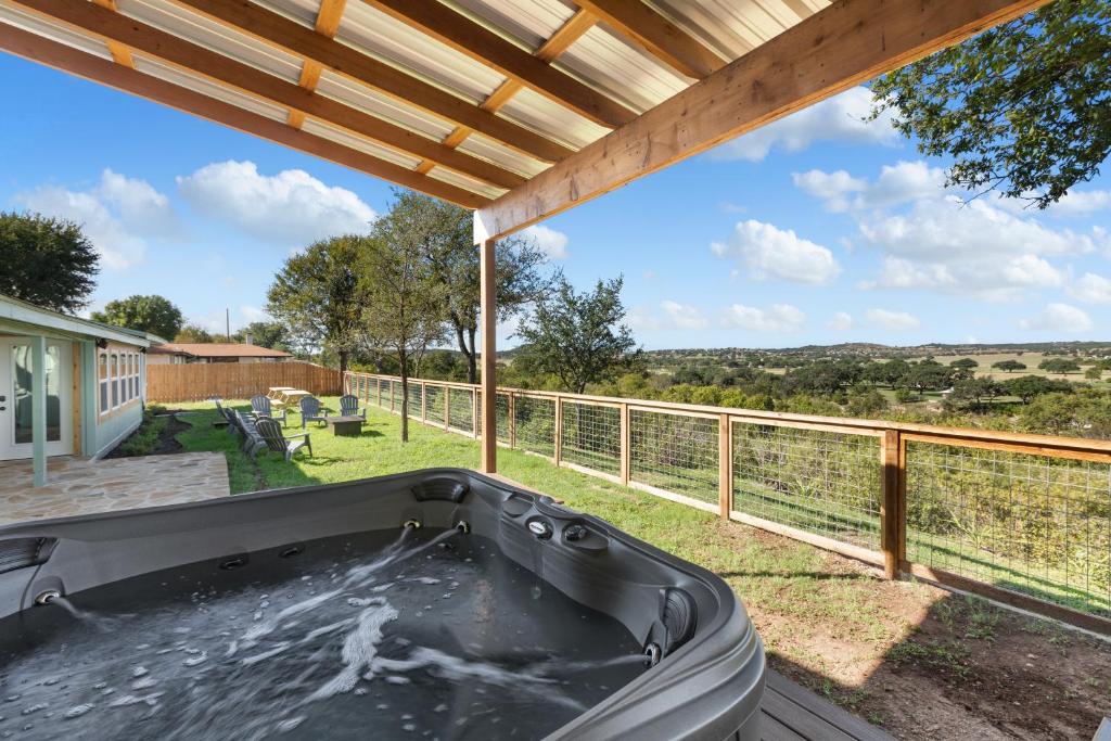 a hot tub on the deck of a house at Guadalupe Bluff Farmhouse in Kerrville