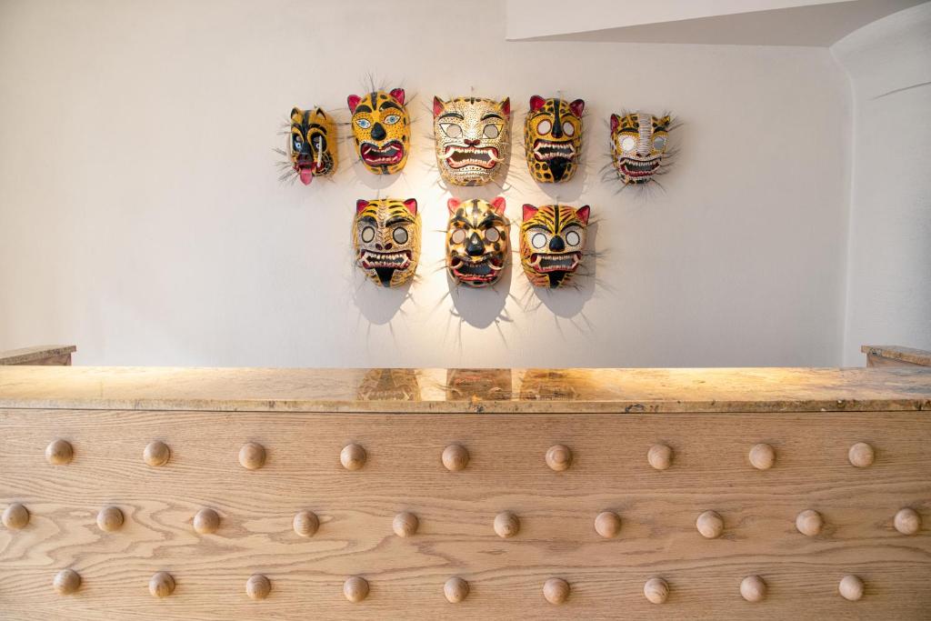 Una pared con máscaras colgando de una pared en William Hotel Boutique De Diseño, en Taxco de Alarcón