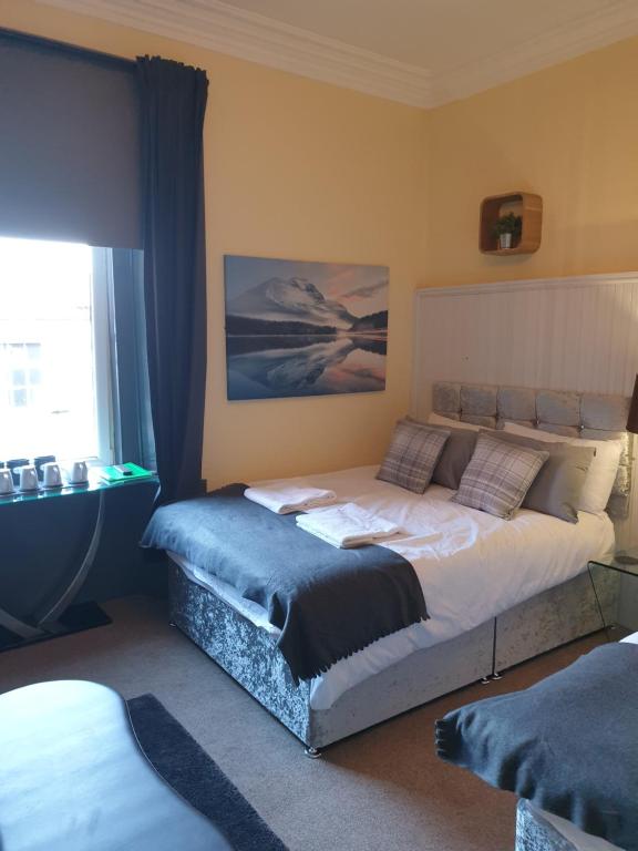 een slaapkamer met een groot bed en een raam bij The Residence - 47 Minto St in Edinburgh