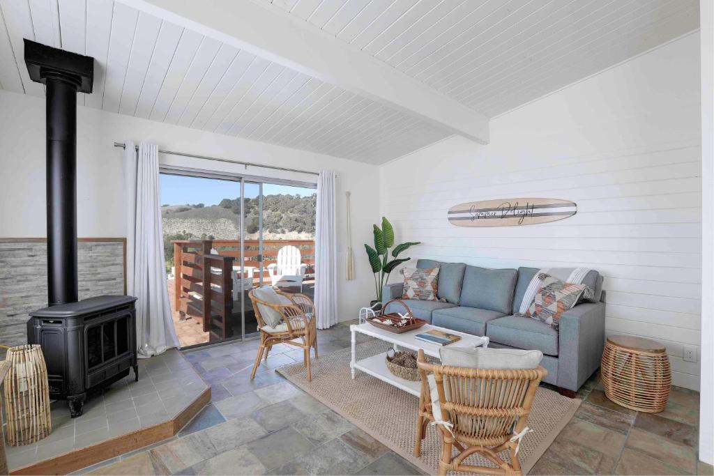 Una sala de estar con un sofá y una estufa. en Summer Delight, en Avila Beach