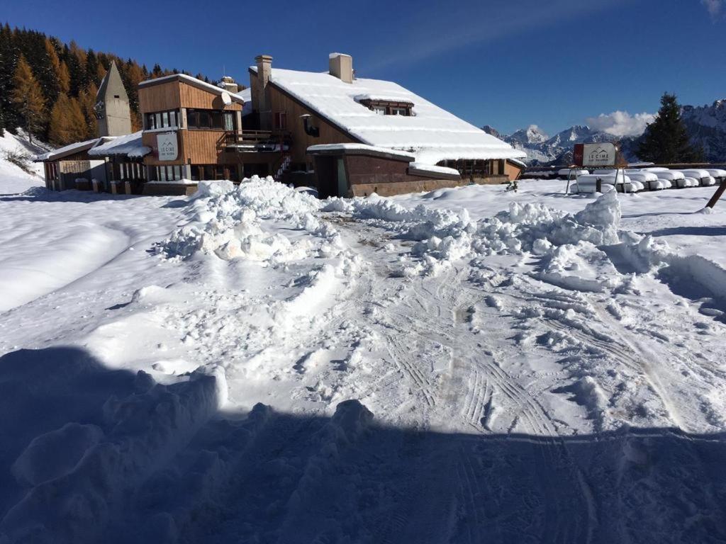 une pile de neige devant une maison dans l'établissement Casa Neve e Sole - presso Sussy Residence, à Falcade