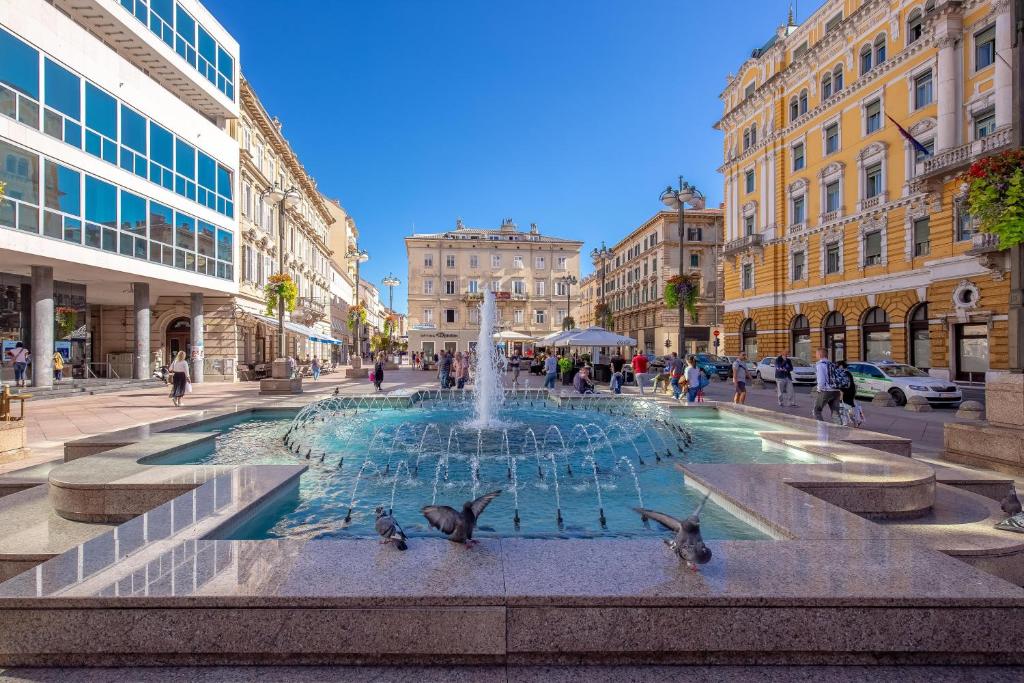 a fountain in the middle of a street with buildings at Adria Square Studios in Rijeka