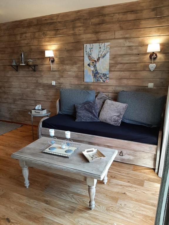 a living room with a couch and a coffee table at VALMEINIER - LE GRAND PANORAMA II - Piscine intérieure in Valmeinier