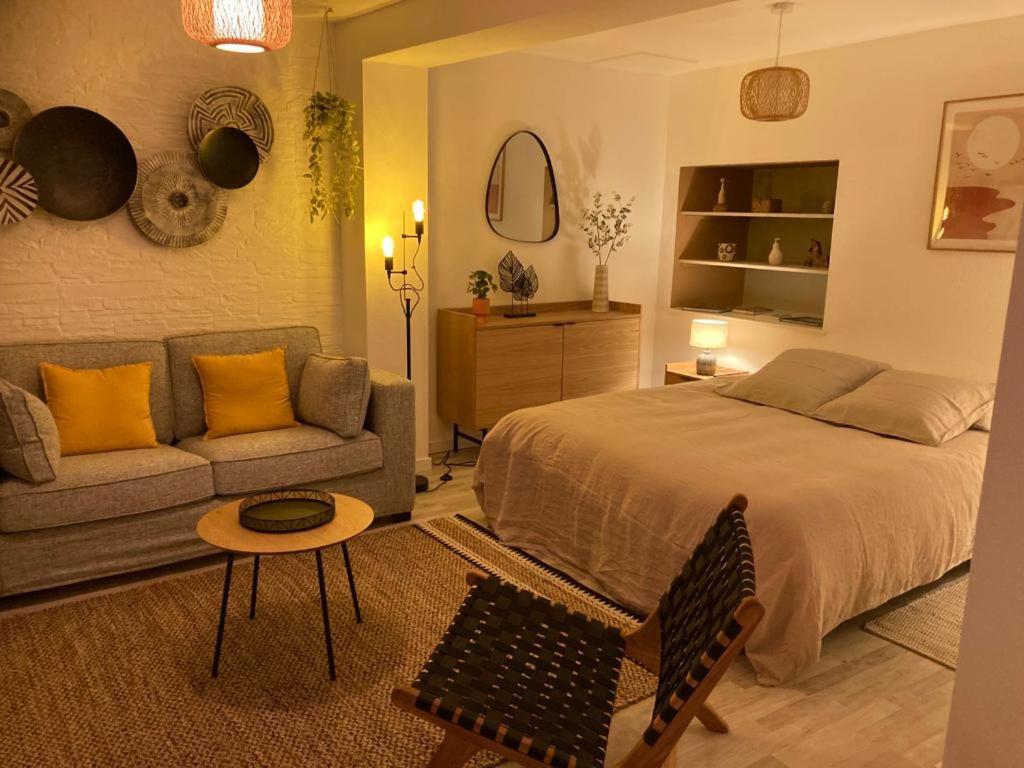 um quarto com uma cama, um sofá e uma mesa em Calme et cosy em Obernai
