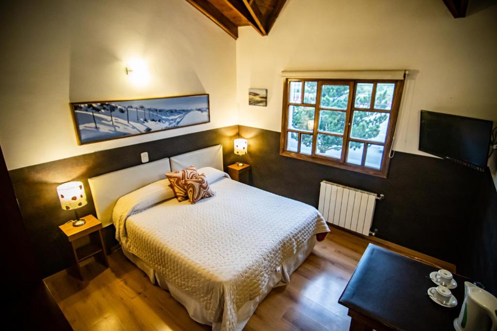 1 dormitorio con cama y ventana en Las Avutardas Hosteria en El Calafate