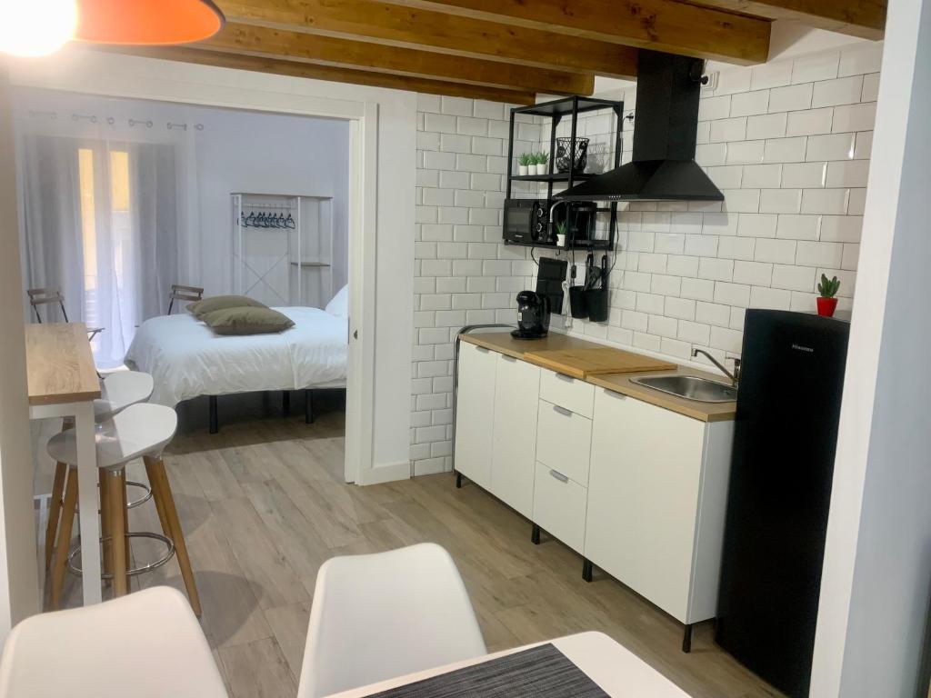 una cucina con lavandino e una camera con letto di Puerta de Caceres Apartamento 3 a Cáceres