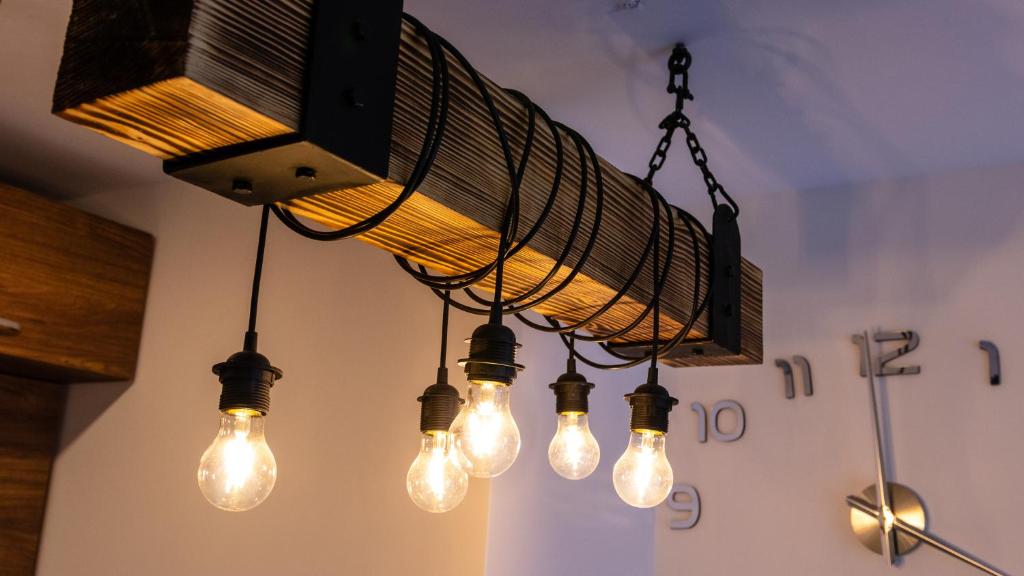 un lustre avec des lumières suspendues au plafond dans l'établissement Borovets Gardens B30 Morunov Apart, à Borovets