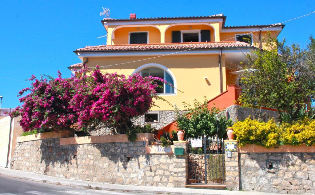Villa le Bougainvillea في لا ماداّلينا: منزل به زهور على جدار حجري