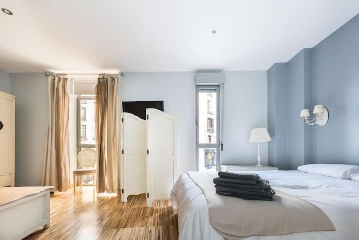 a bedroom with a large white bed with blue walls at Wonder Apartments in Madrid