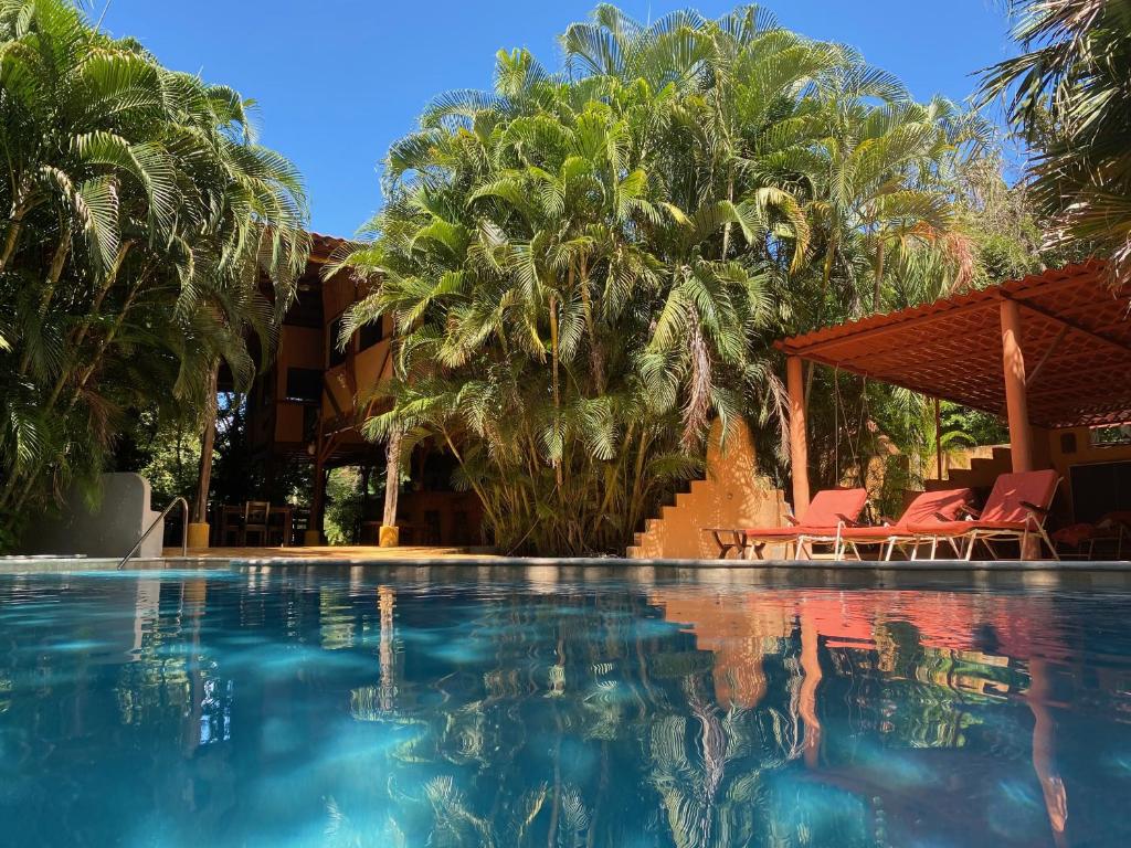 a pool at a resort with palm trees at Mundo Milo Eco Lodge in Paraíso