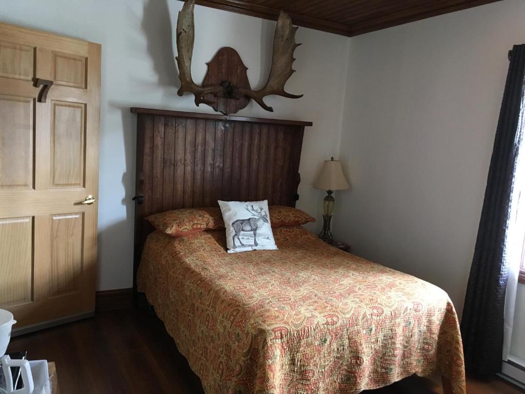 a bedroom with a bed with a pillow on it at Auberge du Vieux Faubourg in Sainte-Anne-des-Monts
