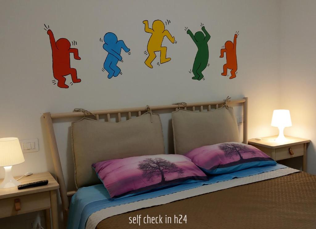 a bedroom with a bed with colorful children on the wall at Piccola Pisa (zona Ospedale Cisanello) in Pisa