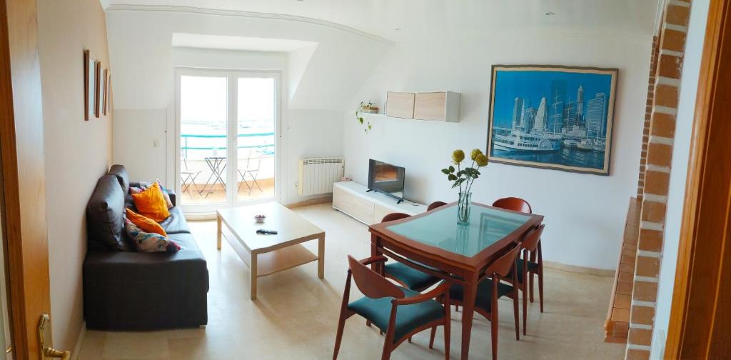 salon ze stołem i jadalnią w obiekcie Precioso ático con vistas a pie de playa w mieście Sanxenxo