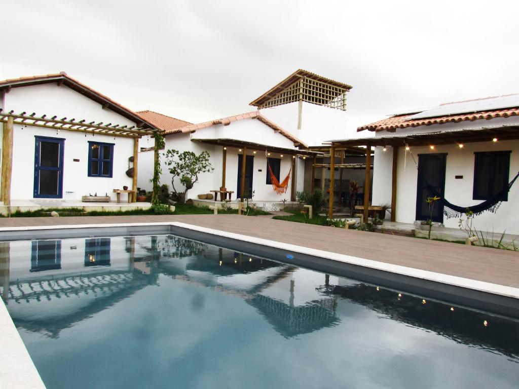 a villa with a swimming pool in front of a house at Aldeia Corumbau in Corumbau