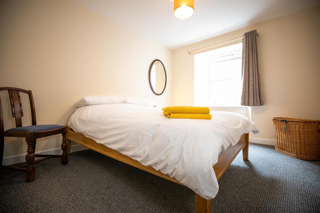 a bedroom with a bed with a yellow towel on it at The Starry Rock in Kirriemuir