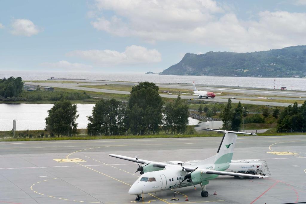an airplane is parked on the runway at an airport at Radisson Blu Hotel, Trondheim Airport in Stjoerdal