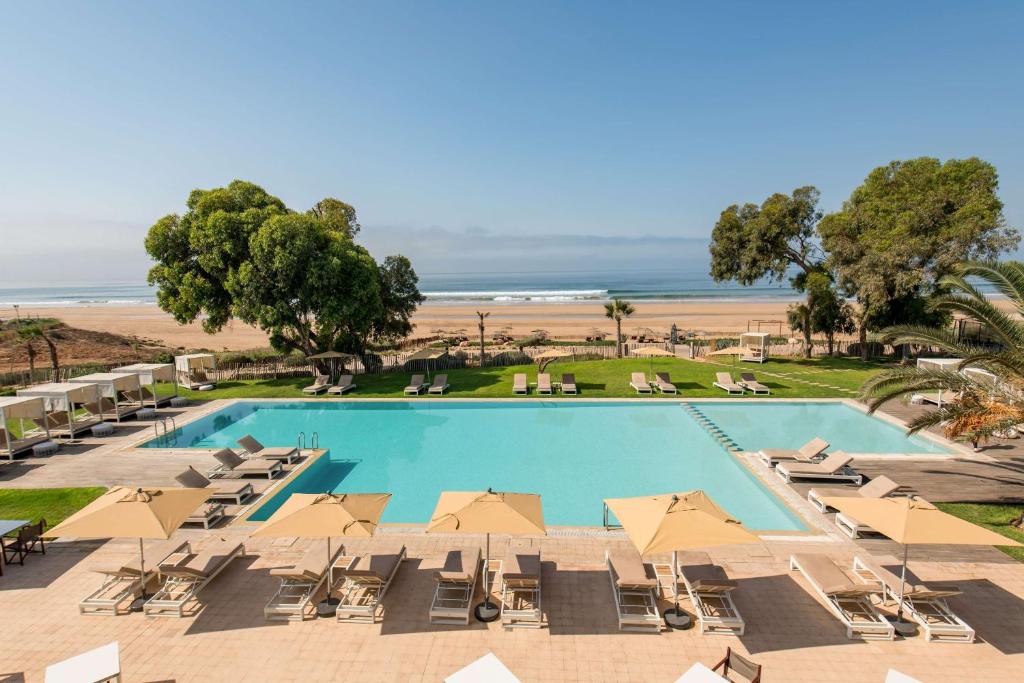 an overhead view of a pool with chairs and umbrellas at Radisson Blu Resort Taghazout Bay Surf Village in Taghazout