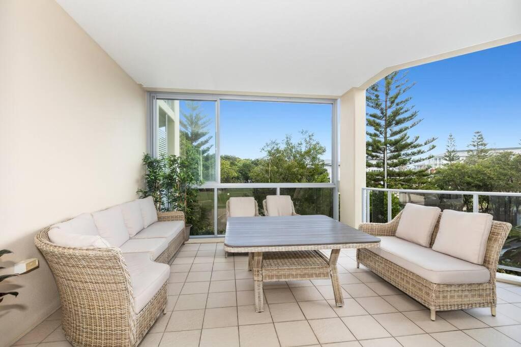 a screened in porch with a table and chairs at Bale Luxury Resort - Holiday Management in Kingscliff