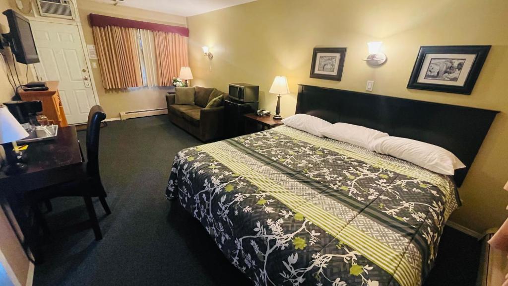 ein Hotelzimmer mit einem Bett und einem Wohnzimmer in der Unterkunft Travellers Motel in Cranbrook