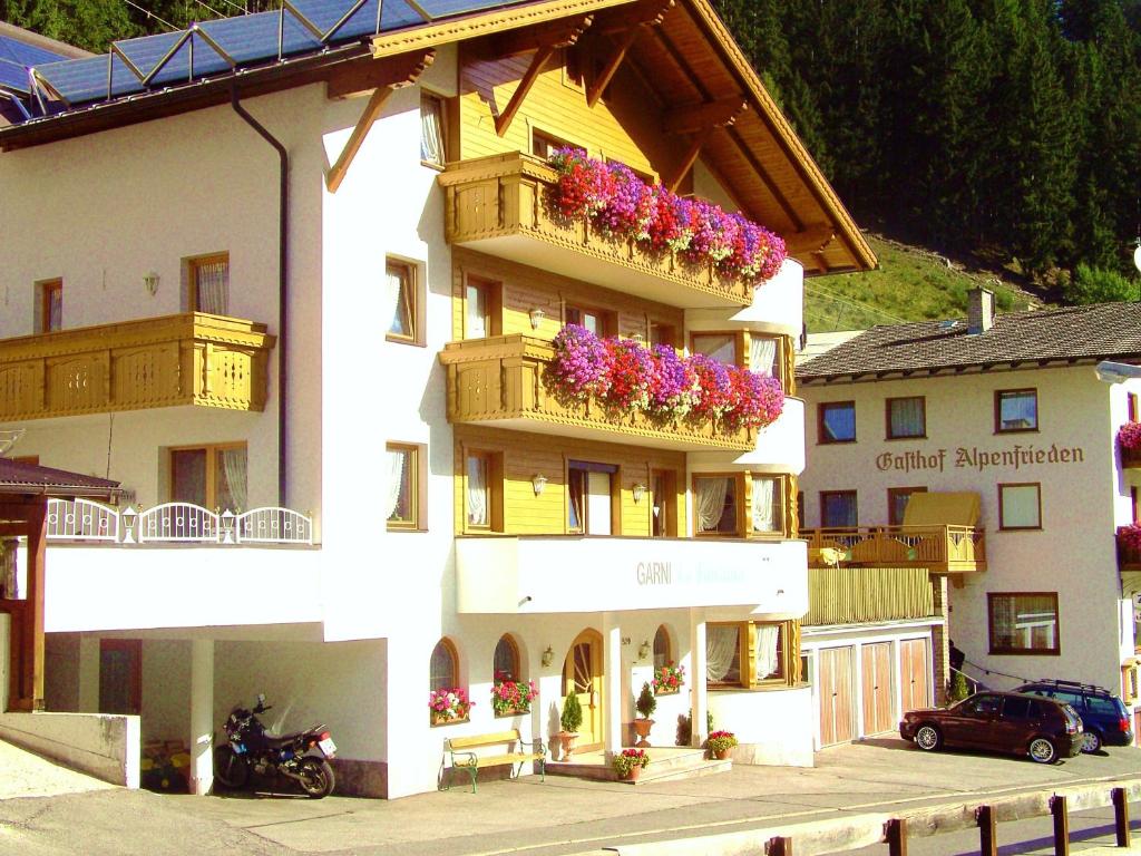 a building with flower boxes on the balconies at Apart Garni La Fontana in Kappl