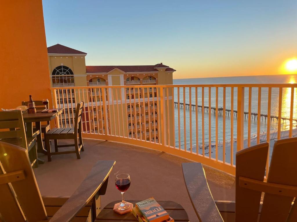 Calypso 3-2303 Penthouse Level w/ Incredible View! في بنما سيتي بيتش: شرفة مع طاولة وكأس من النبيذ