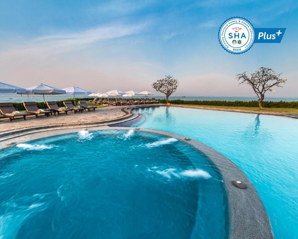 a large swimming pool with a blue sky at Dusit Thani Pattaya - SHA Extra Plus in North Pattaya