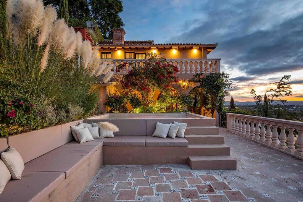 a patio with a couch in front of a house at Casa Vista 6BR Villa, 16p Jacuzzi Pool, Staff & Breakfast in San Miguel de Allende