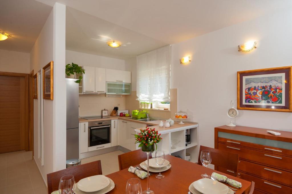 a kitchen with a table with chairs and a dining room at Apartments Maja in Omiš