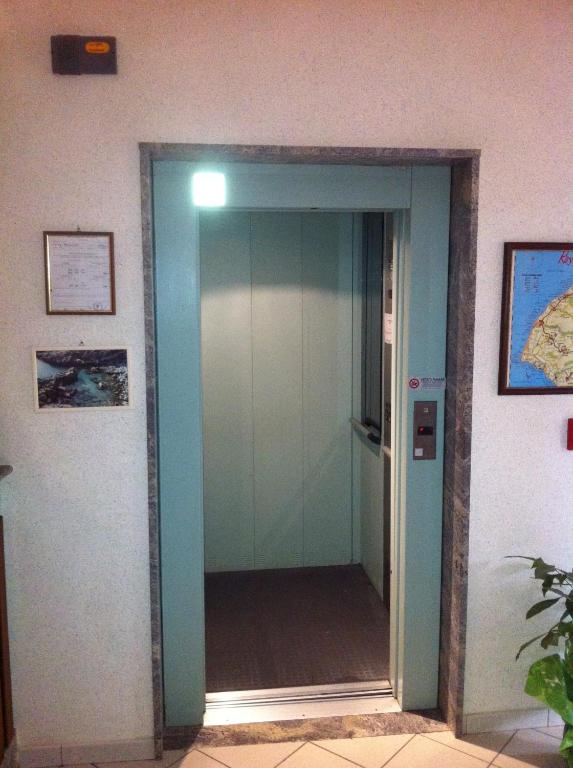 an elevator in a room with a glass door at Hotel Royal in Coccorino
