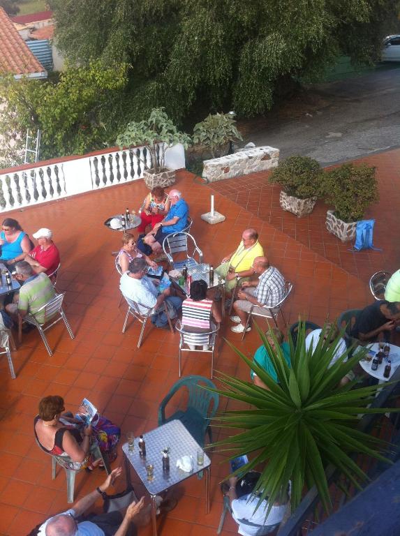 a group of people sitting at tables on a patio at Hotel Royal in Coccorino