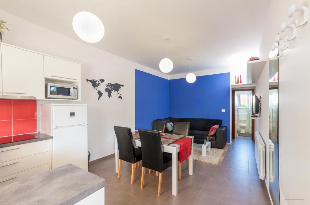 a kitchen and living room with a table and chairs at Apartment Indigo in Zadar