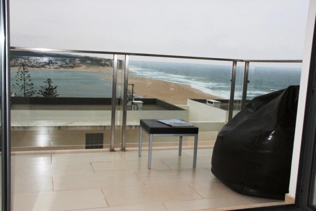 a balcony with a table and a view of a beach at Apartamento Foz Arelho in Foz do Arelho