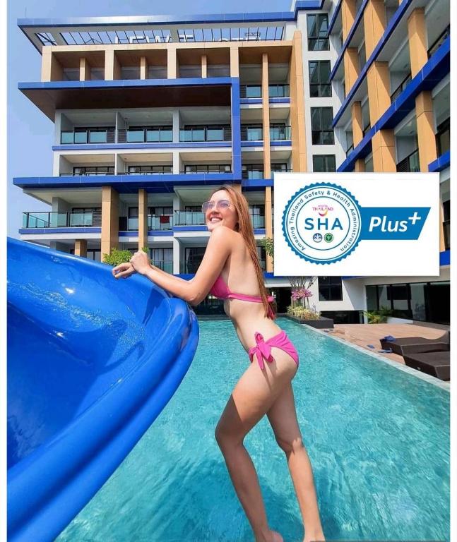 ein junges Mädchen im Bikini auf einer Rutsche in einem Schwimmbecken in der Unterkunft Lewit Hotel Pattaya, a member of Radisson Individuals in Pattaya South