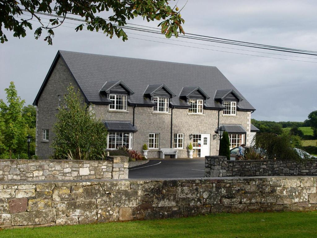 
a large stone building with a clock on it's side at Michaeleen's Manor B&B in Cong
