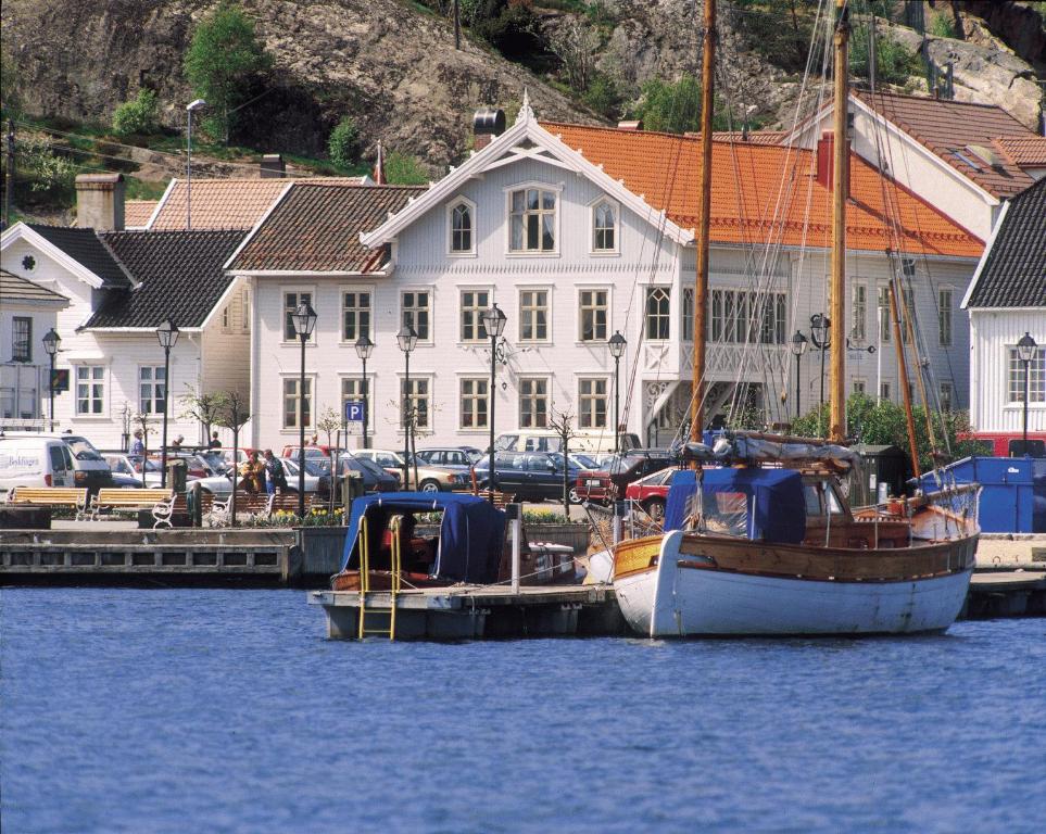 un barco atracado en un puerto deportivo frente a un edificio en Lillesand Hotel Norge en Lillesand