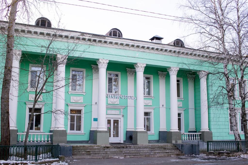 un edificio verde y blanco con columnas en Park Hotel, en Severodvinsk