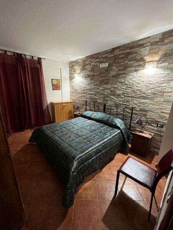 1 dormitorio con cama y pared de piedra en B&B San Domenico, en Realmonte