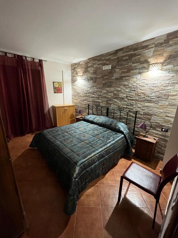 a bedroom with a bed and a stone wall at B&B San Domenico in Realmonte