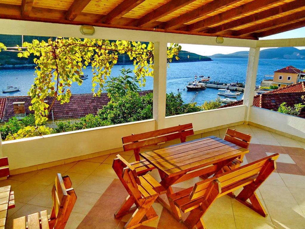 - une table et des chaises sur une terrasse couverte offrant une vue sur l'eau dans l'établissement Apartments Vesna, à Tivat