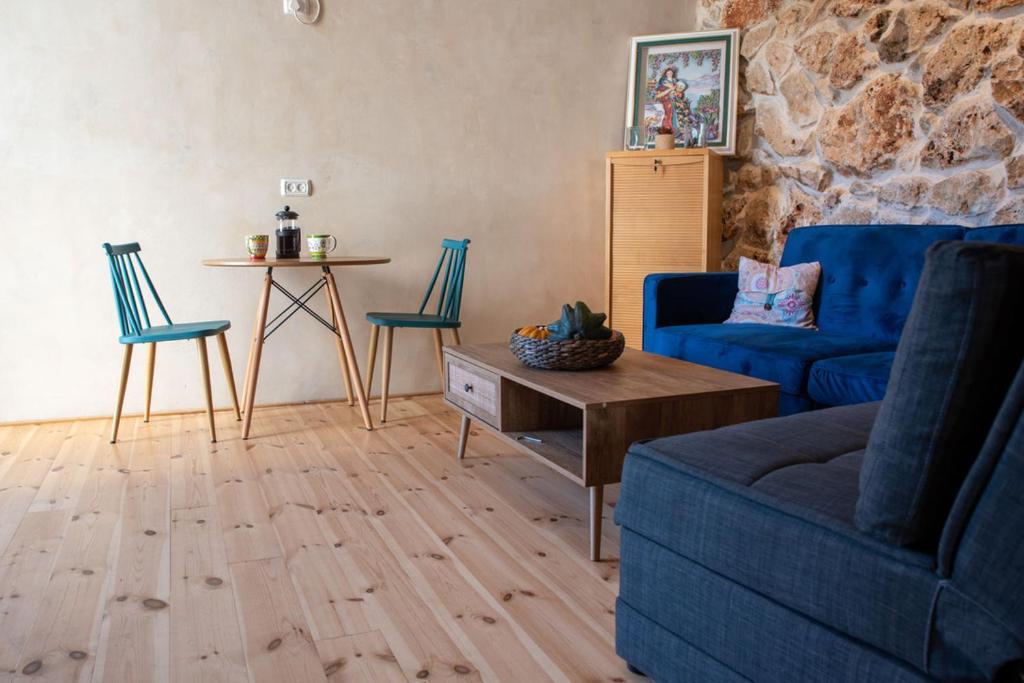 uma sala de estar com um sofá e cadeiras azuis e uma mesa em Cozy Galilee Getaway em Abirim