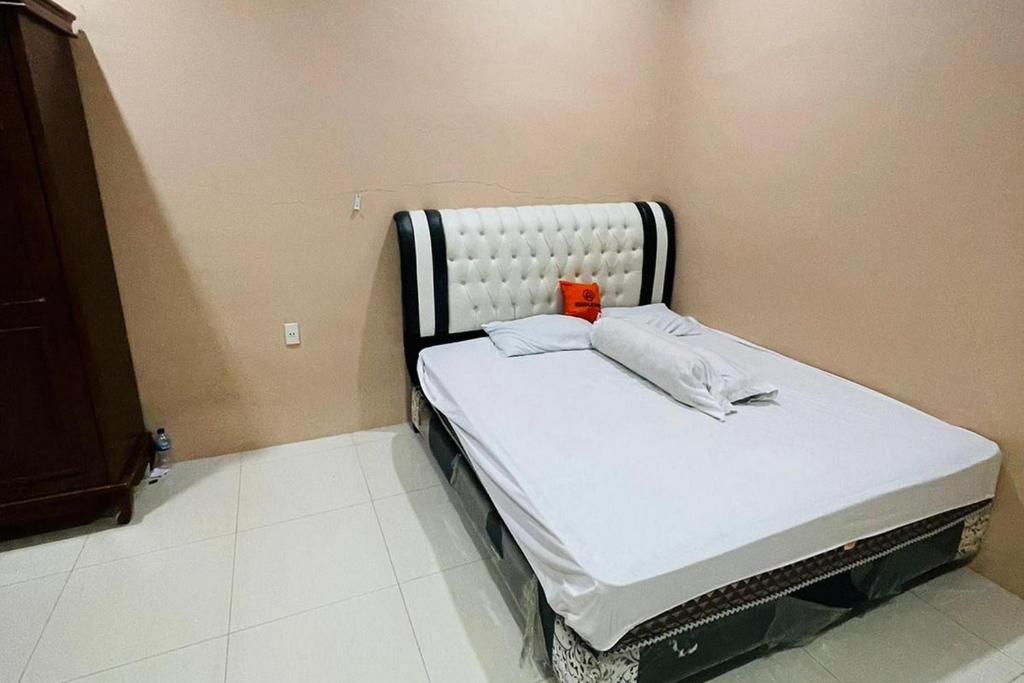 una pequeña cama de hospital en una esquina de una habitación en KoolKost @ Jalan Polonia Medan (Minimum Stay 6 Nights) en Medan