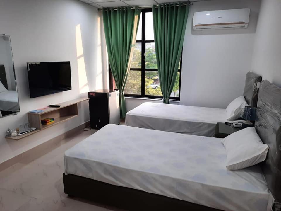 pokój hotelowy z 2 łóżkami i telewizorem w obiekcie Sultan Executive Hotel w mieście Dargai