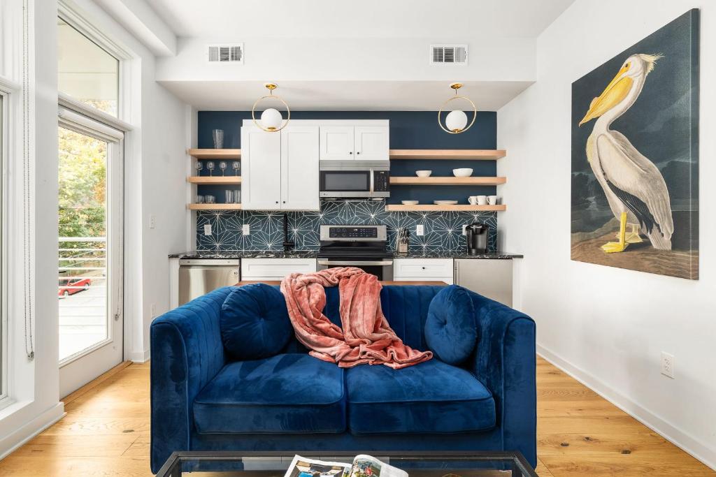 un sofá azul en una sala de estar con cocina en Marvelous Midtown Manor In Piedmont Park en Atlanta