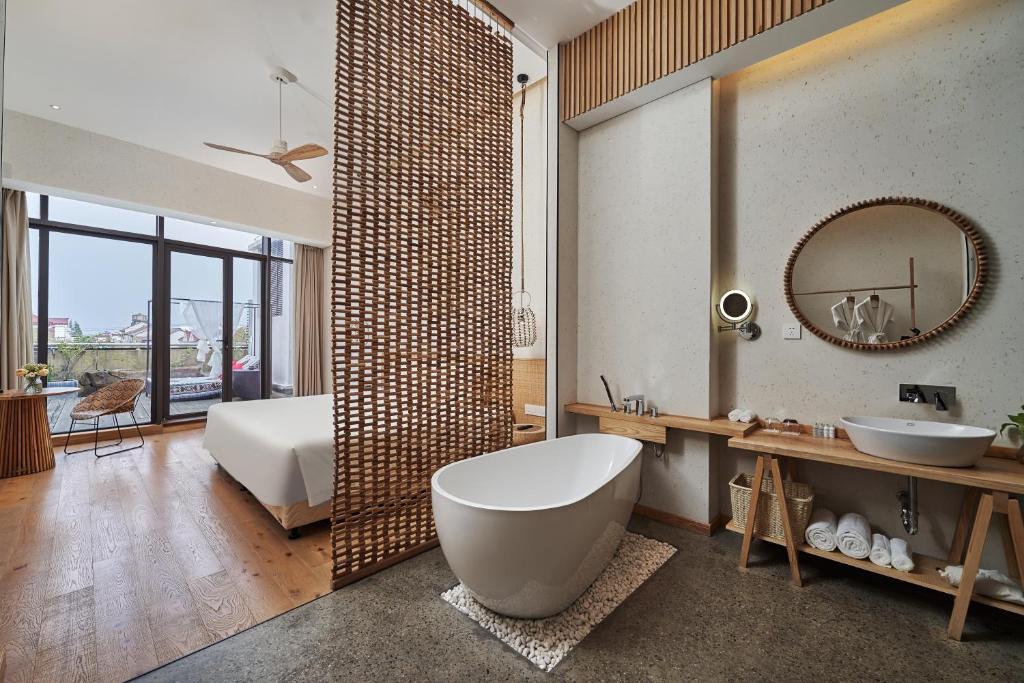 a bathroom with a tub and a sink and a mirror at Moonlo Hotel - Pet Friendly - Pudong Airport & Disney Free Shuttle Bus in Shanghai