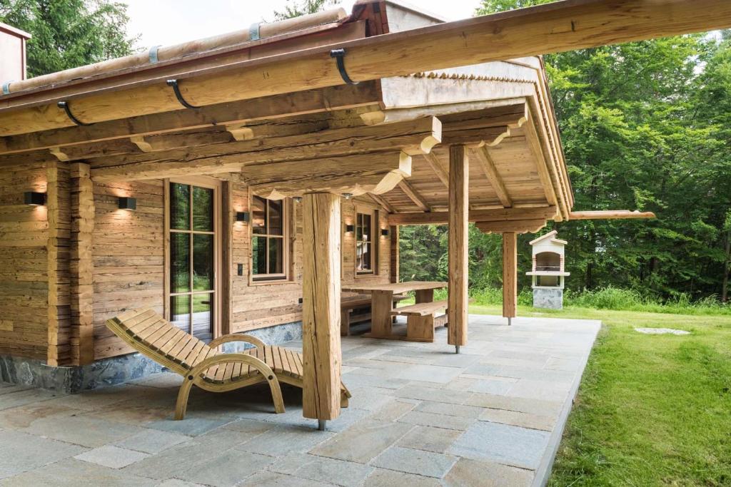 un pabellón de madera con un banco en el patio en Chalet-karwendel en Terfens