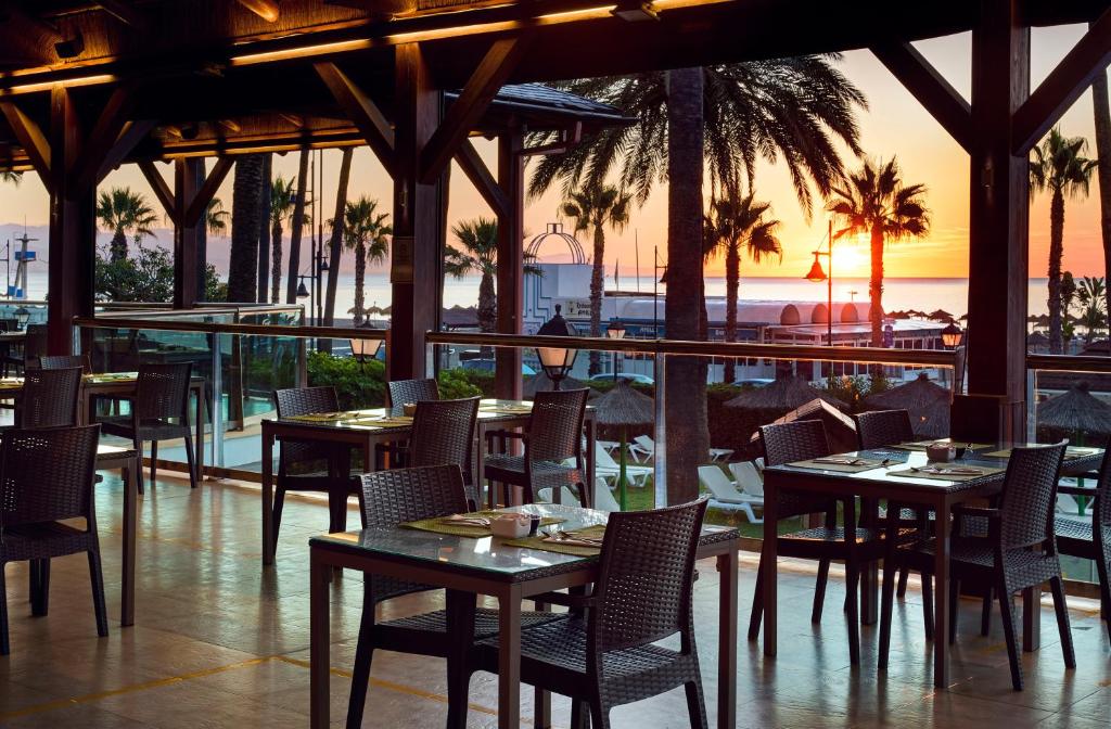 Un restaurante con mesas y sillas con vista al mar. en Sol Principe, en Torremolinos