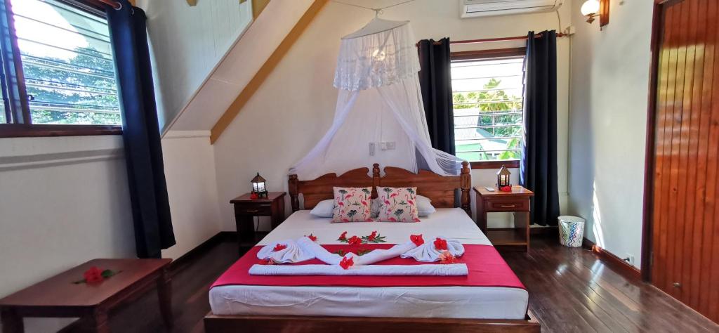 a bedroom with a bed with dolls laying on it at Chalets d'Anse Reunion in La Digue