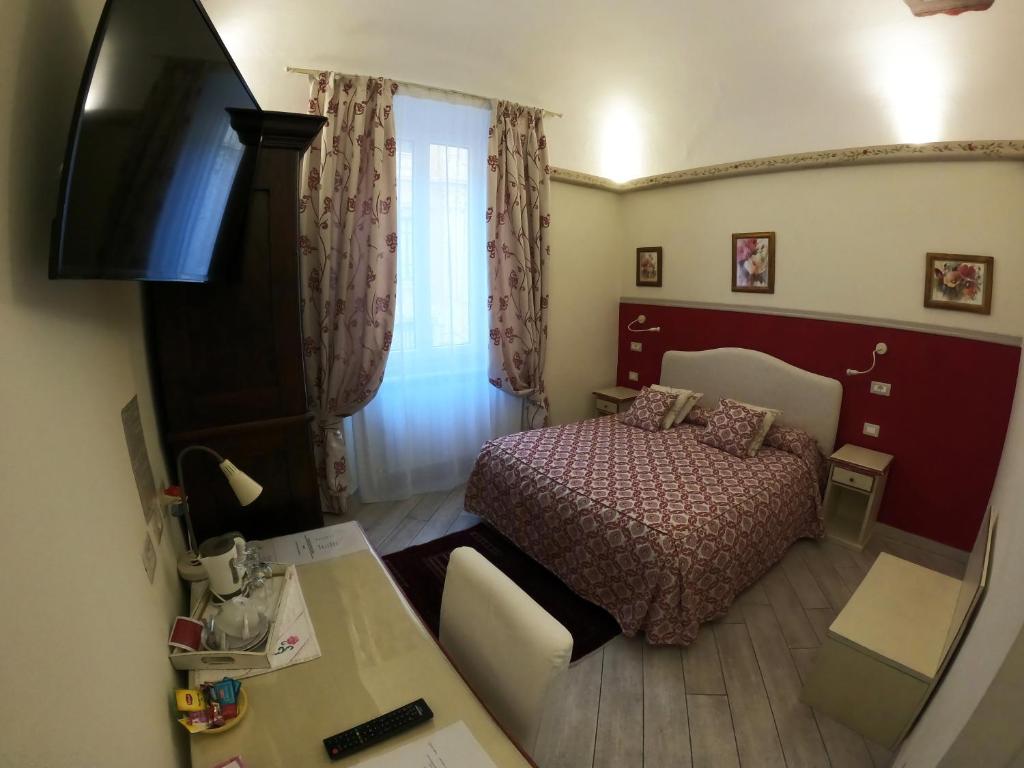 ピサにあるFive Roses Bed & Breakfastのベッド1台とテレビが備わる小さな客室です。