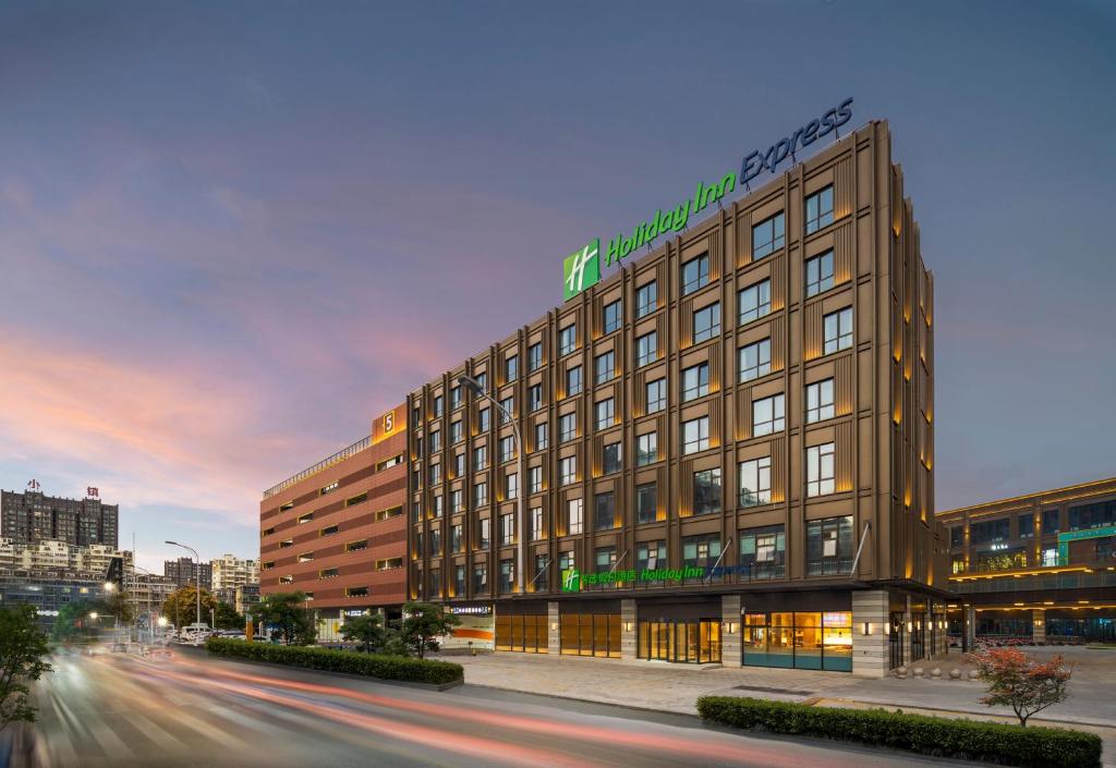 un edificio en una calle de la ciudad con un edificio en Holiday Inn Express Nantong North Gateway, an IHG Hotel en Nantong