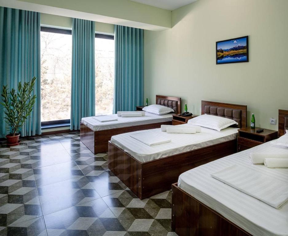 a room with three beds in a room at OQ UY Hotel in Tashkent